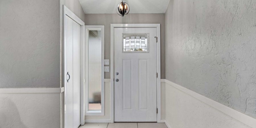Bright entryway with white door and light fixture.