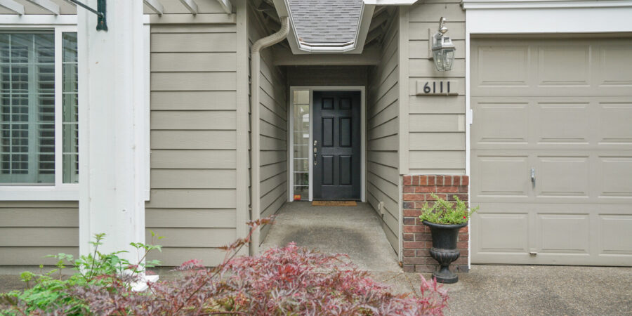 House entrance with black door and plants.