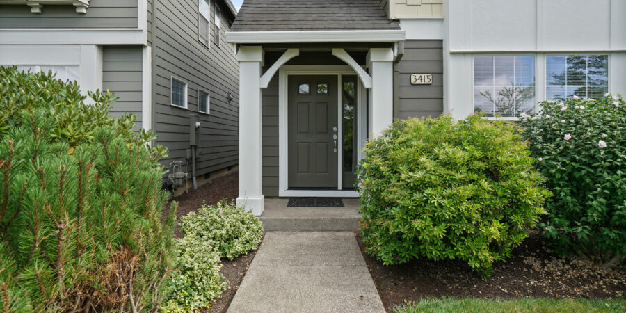 House entrance with gray door and landscaping.