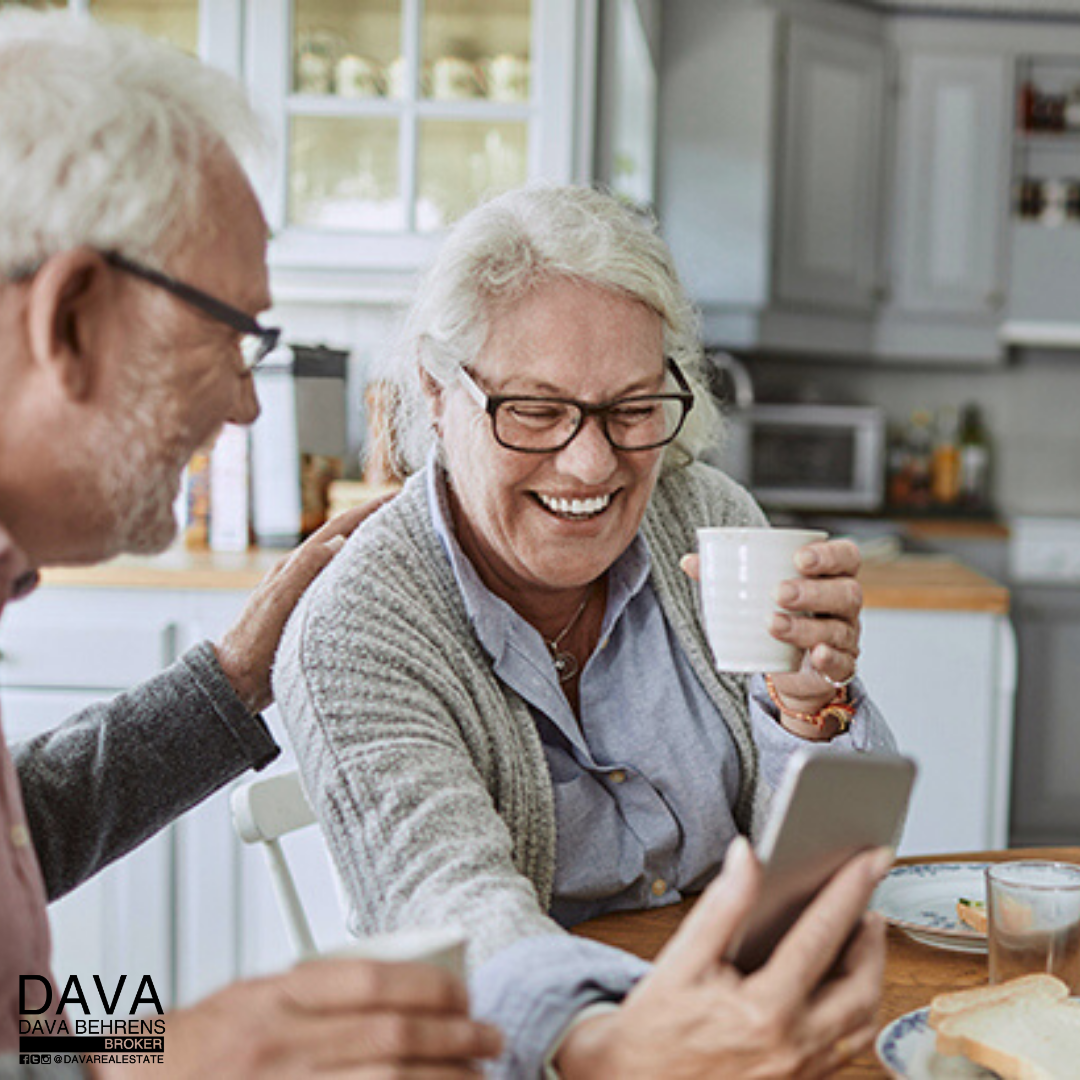 Happy senior couple using phone together.