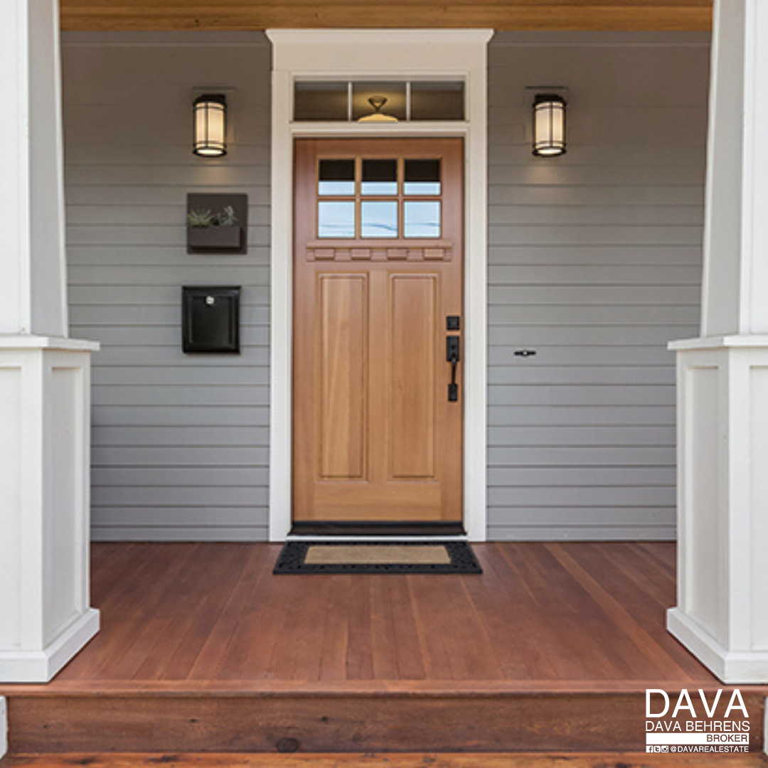 Wooden front door on gray house.