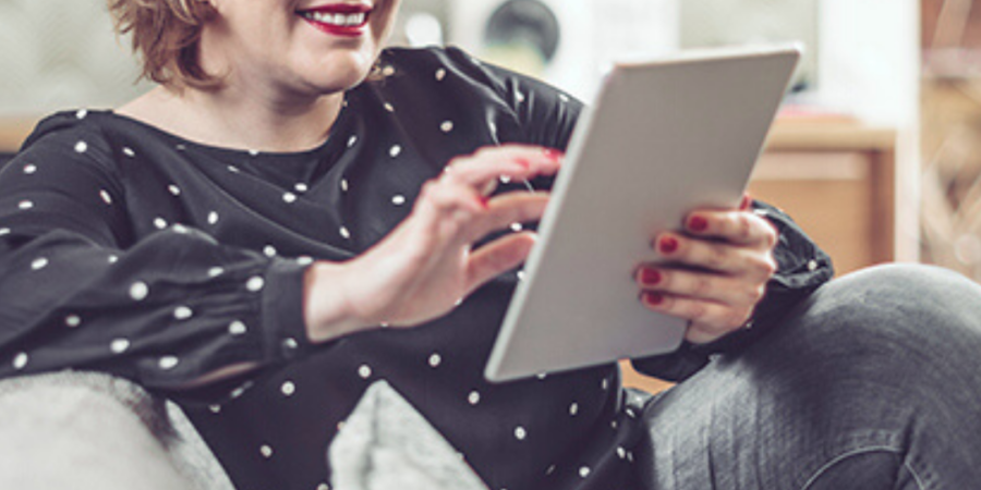 Woman using tablet on sofa.