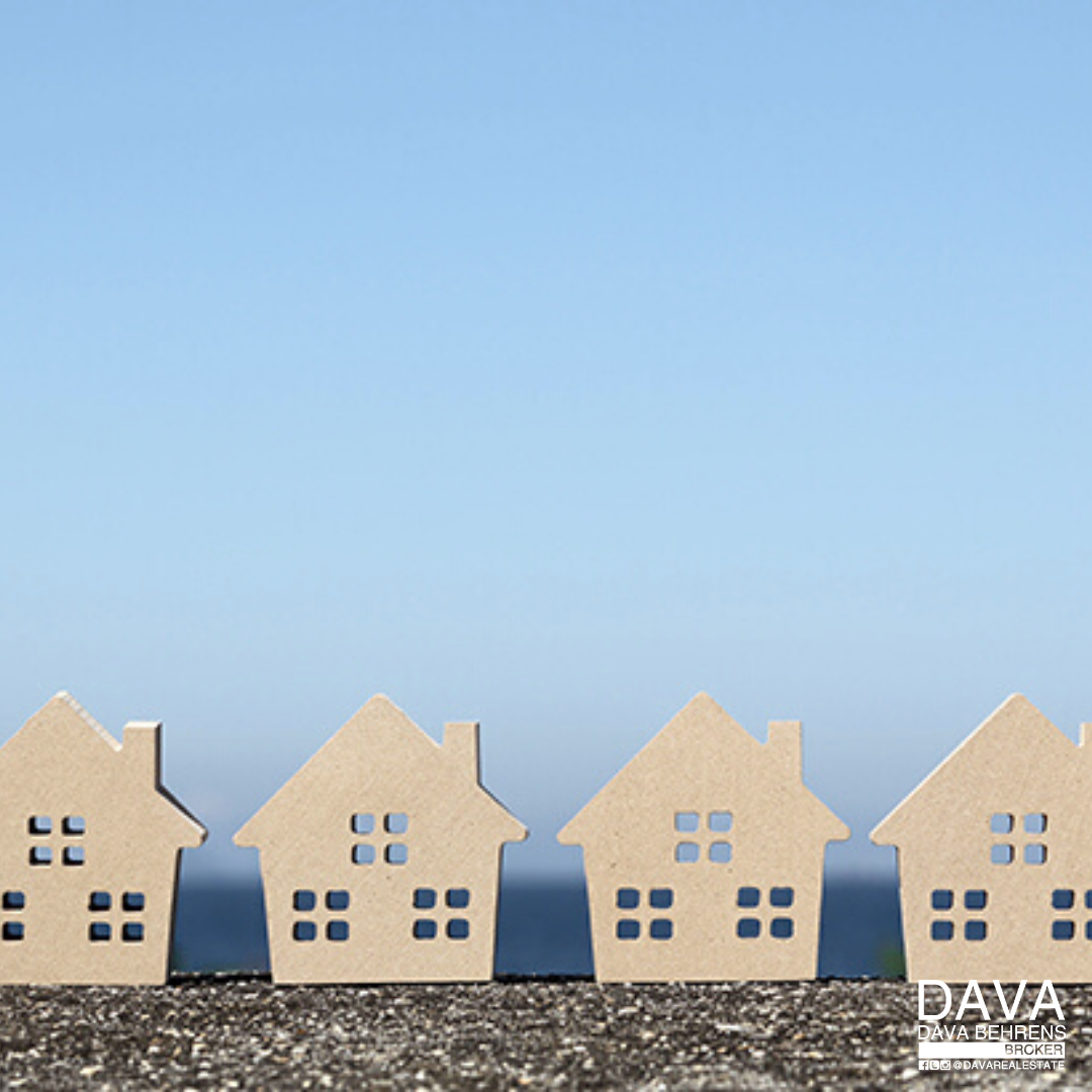 Row of miniature houses under blue sky.