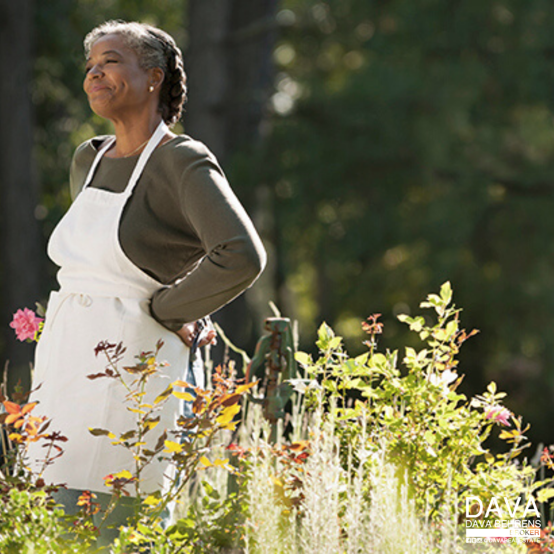 Smiling woman in garden wearing apron.