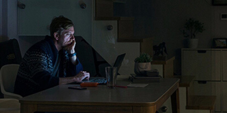 Man working late on laptop at home.