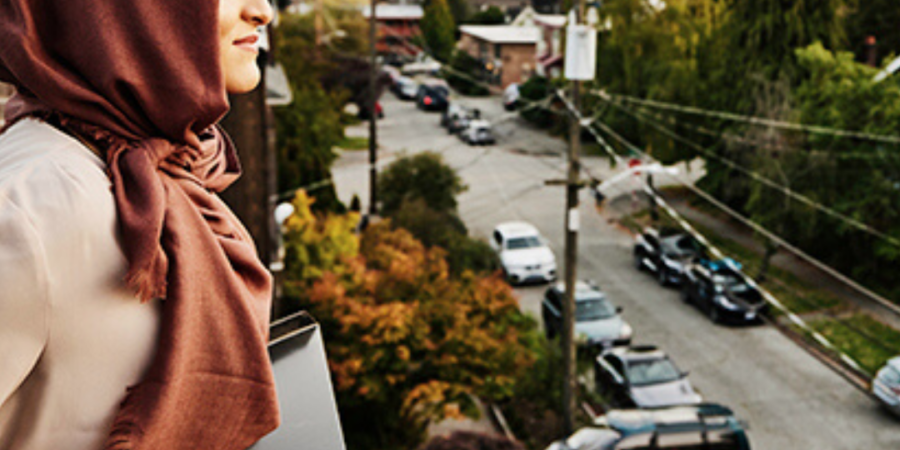 Woman in hijab looking at city view.