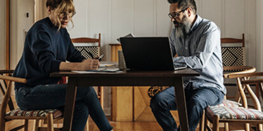 Couple working together at home desk.