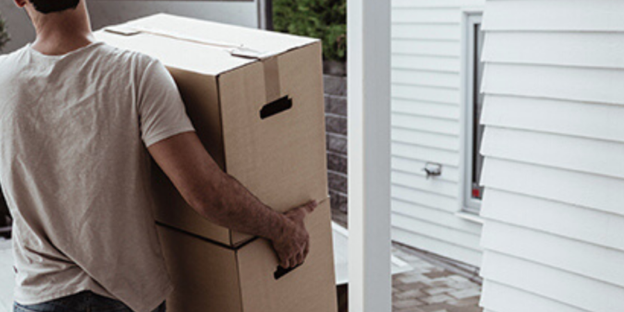 Man carrying cardboard boxes moving home.