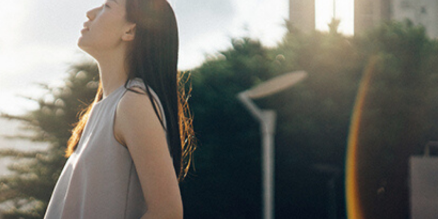 Woman enjoying sunlit city view.