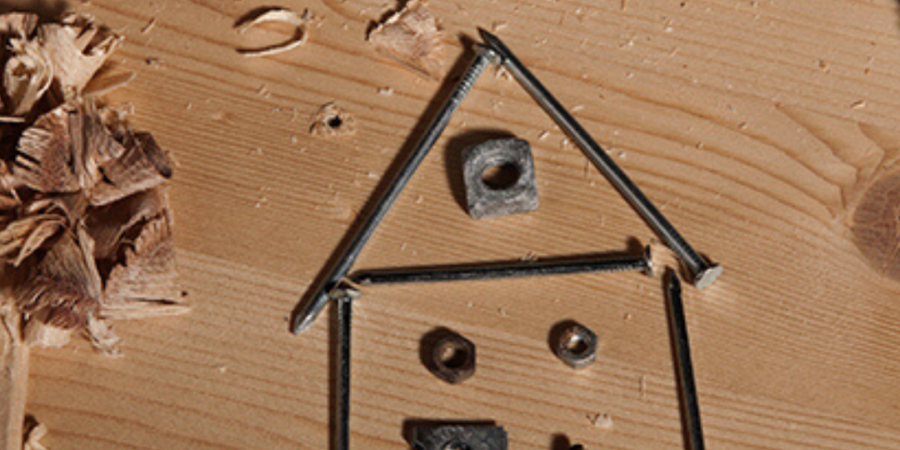 Nails and nuts form house shape.