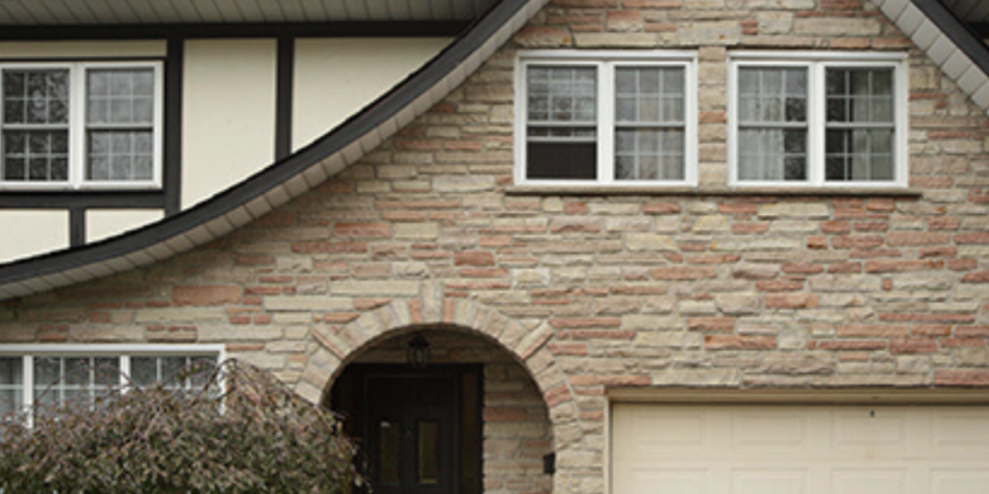 Stone house with arched entryway and garage.