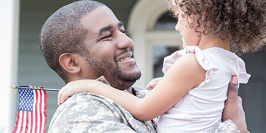 Soldier father hugs his daughter.