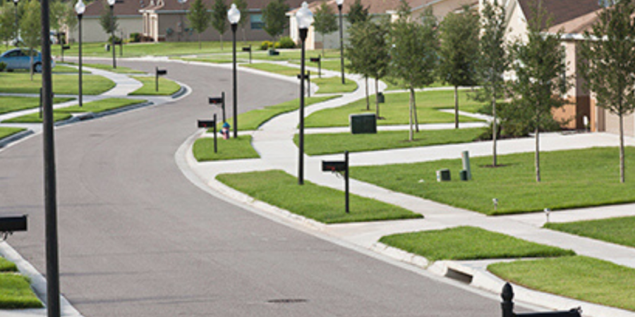 Curving residential street with houses and mailboxes.