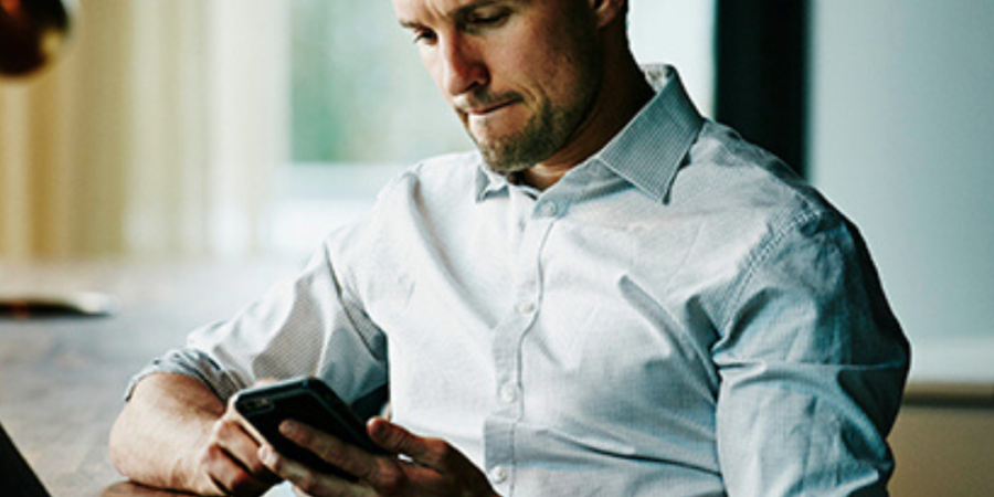 Man in shirt checking his phone.