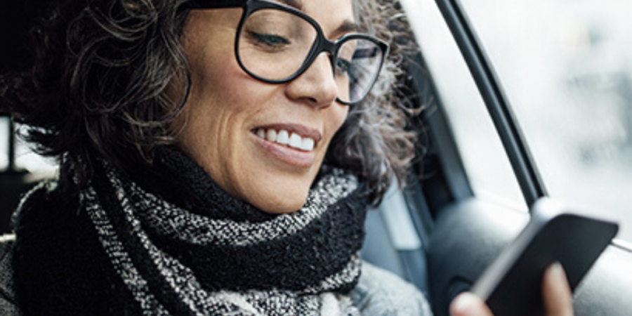 Woman in car using smartphone.