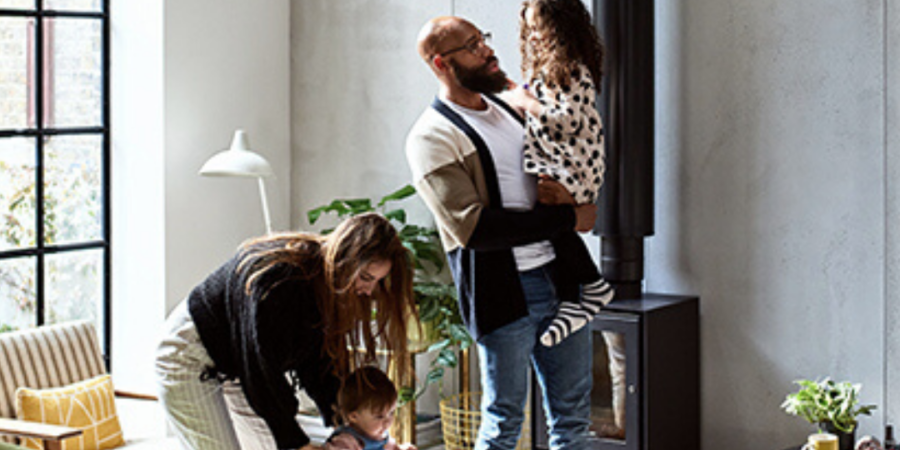 Family with three children by fireplace.