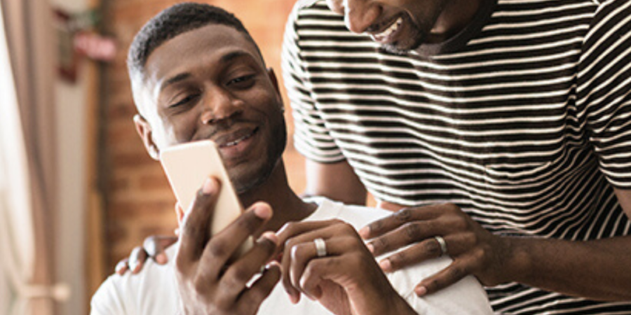 Two men looking at a smartphone together.