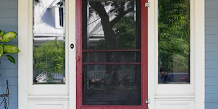 Red front door with screen and sidelights.