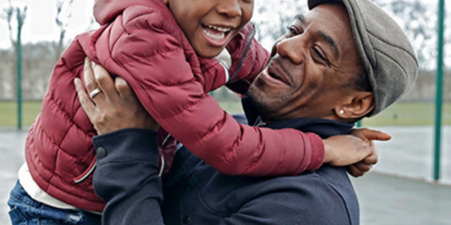 Happy father and son embracing outdoors.