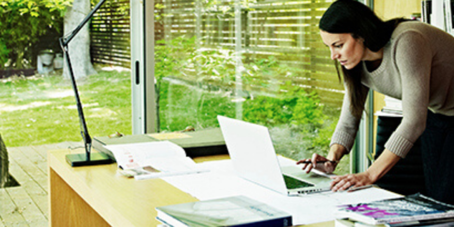 Woman working on laptop at home office.