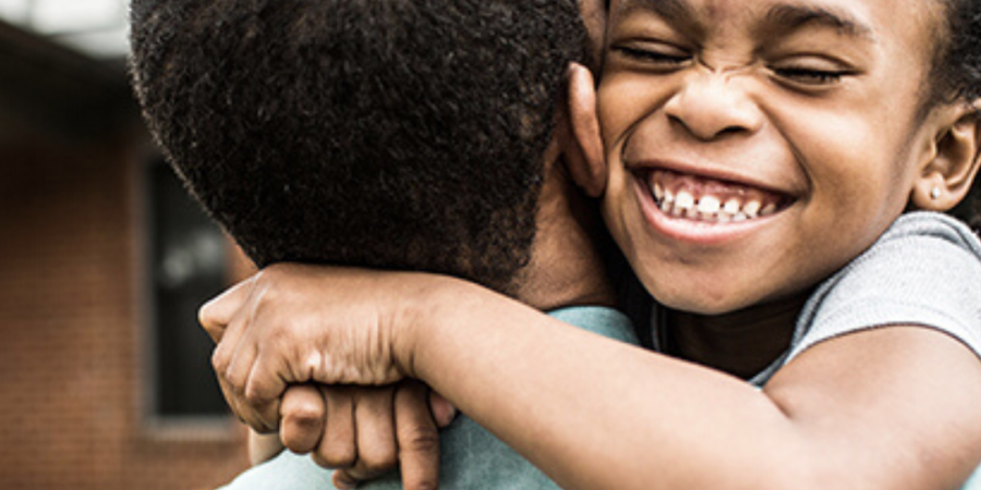 Happy child hugging father tightly.