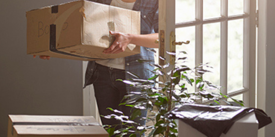 Woman moving boxes into new home.