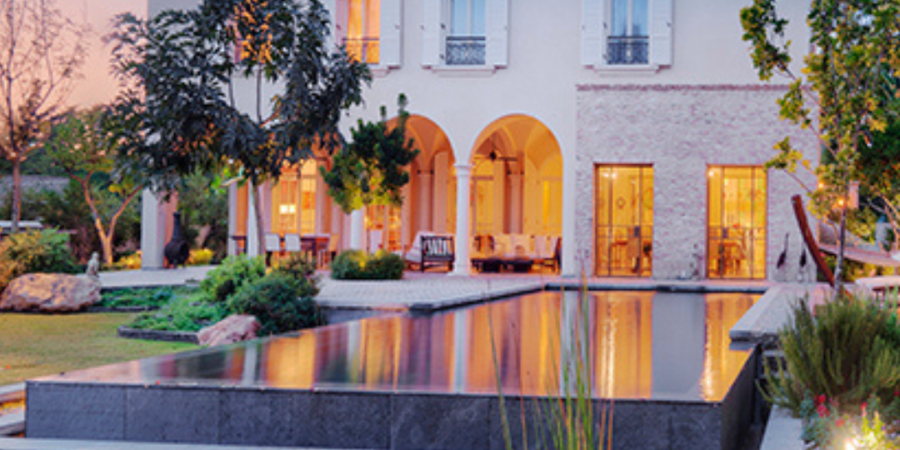 Luxury villa with infinity pool at night.