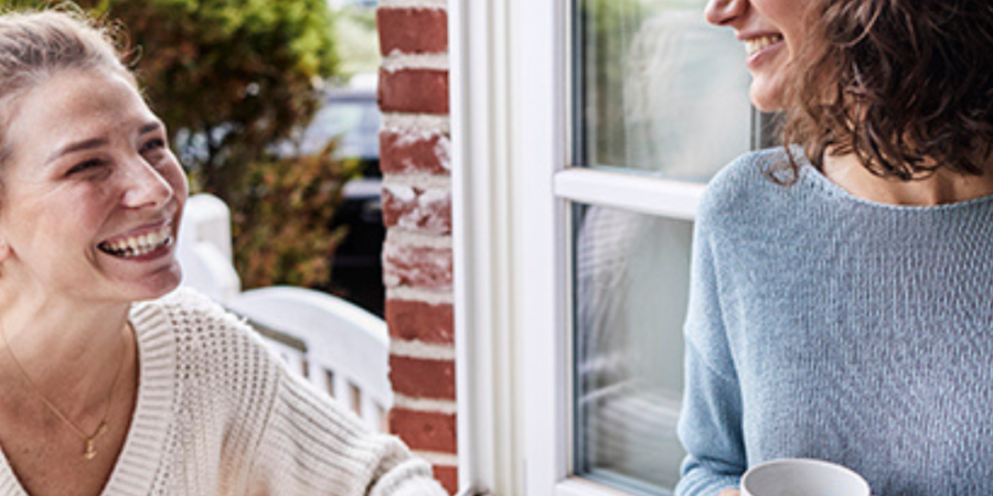 Two women chatting by a window.