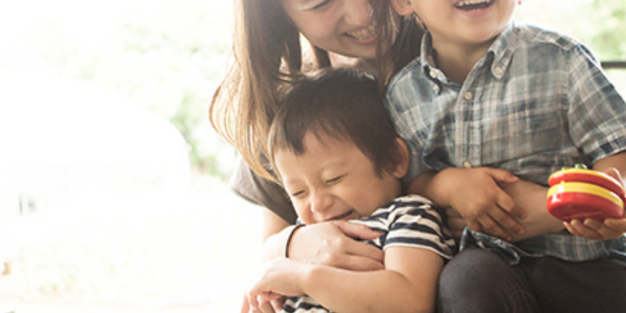 Happy mother hugging her two children.