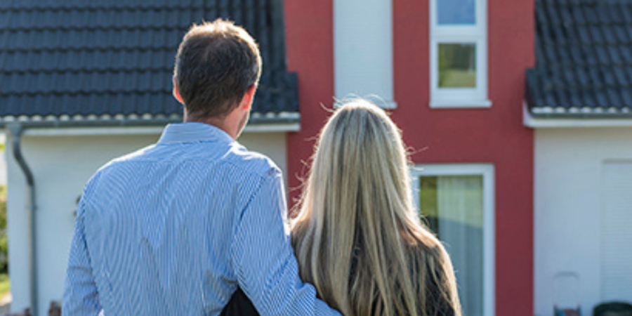 Couple admiring new house exterior.