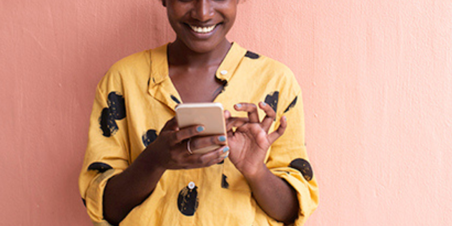 Woman smiling, using smartphone.