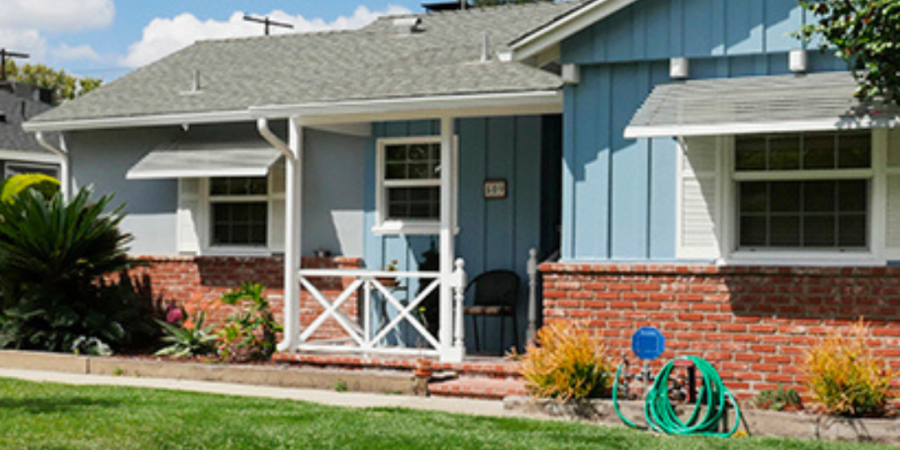 Ranch house with brick and blue siding.