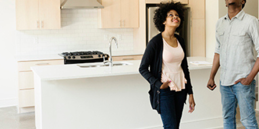 Couple admiring new kitchen in modern home.