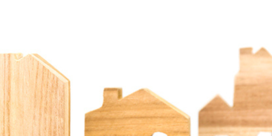 Wooden house models on a wood surface.