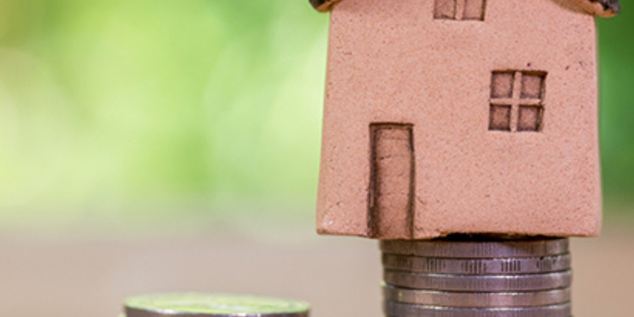 House model on stacks of coins.