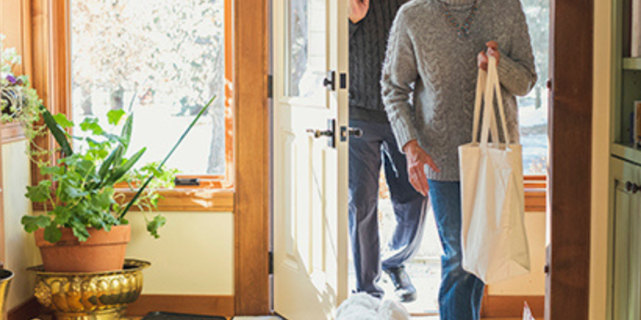 Senior couple leaving home with dog.