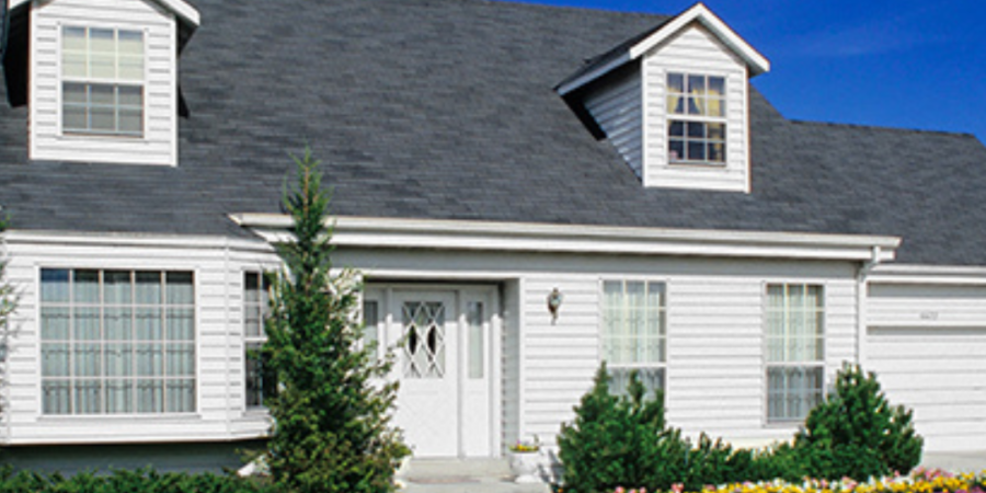 White suburban house with green lawn.