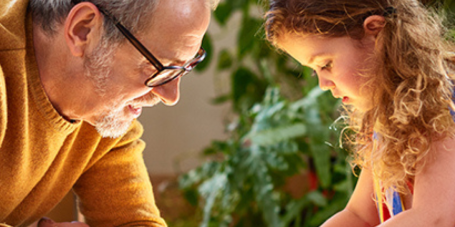 Grandfather and granddaughter playing with blocks.