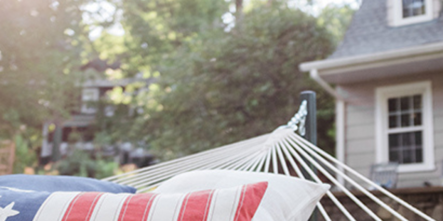 Patriotic pillows in a backyard hammock.