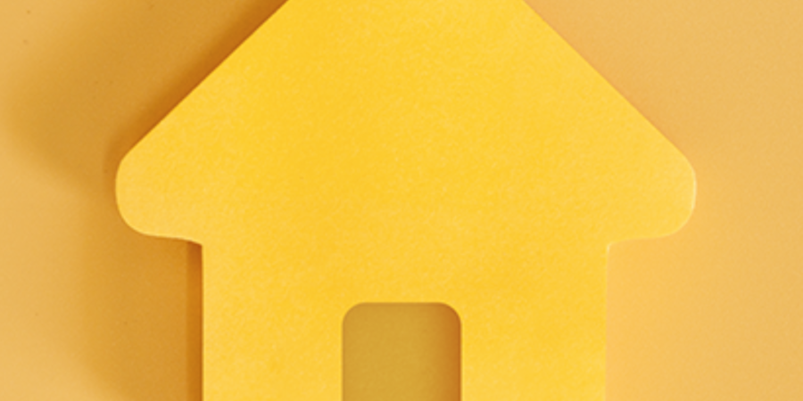 Yellow paper house cutout symbol.