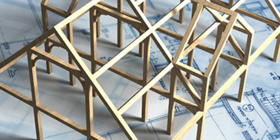 Model of timber frame house on blueprints.