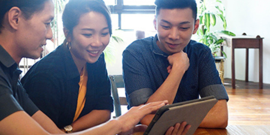 Team viewing tablet screen together.