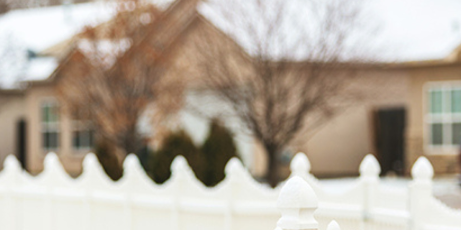 White picket fence, snowy neighborhood.