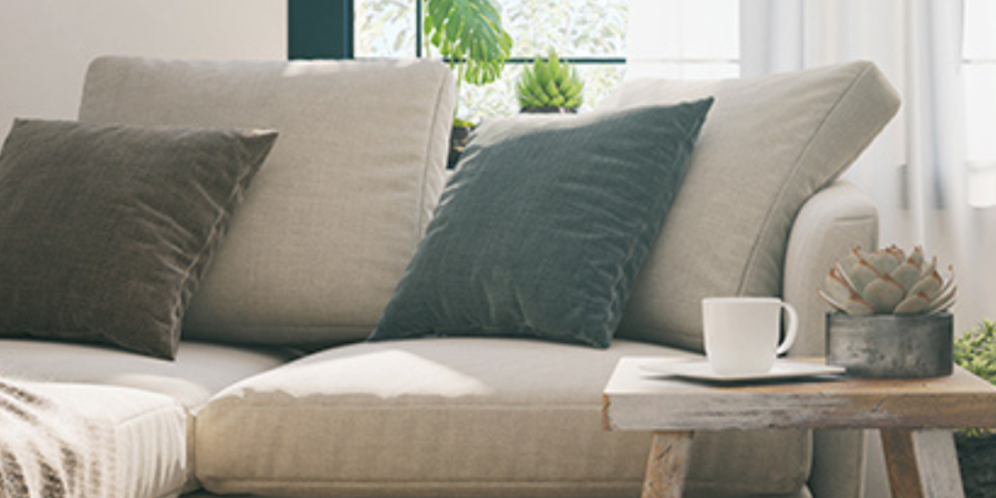 Beige sectional sofa in sunlit living room.