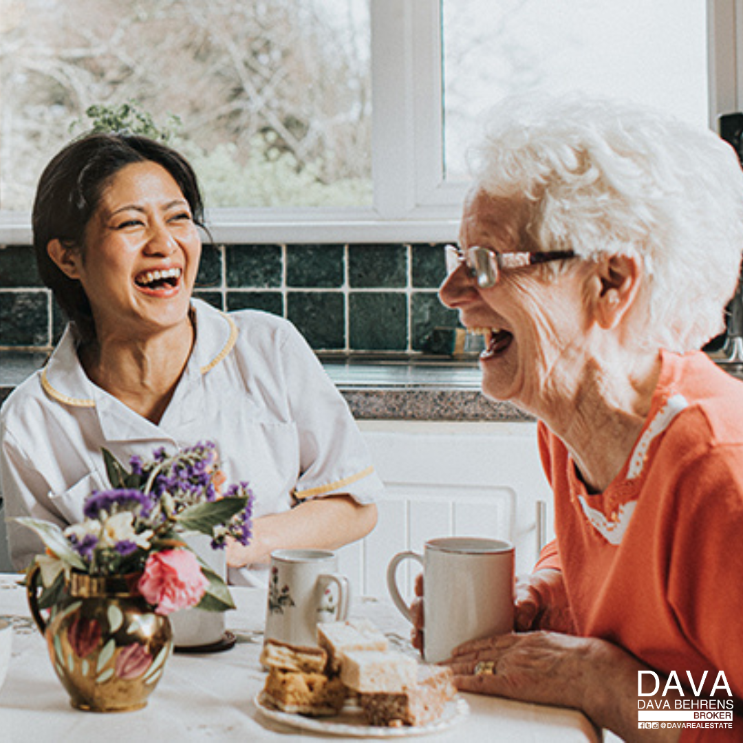 Happy caregiver and senior woman enjoying tea.