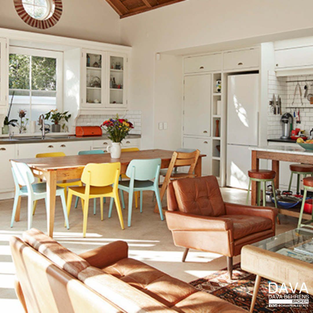 Bright kitchen with colorful dining chairs.