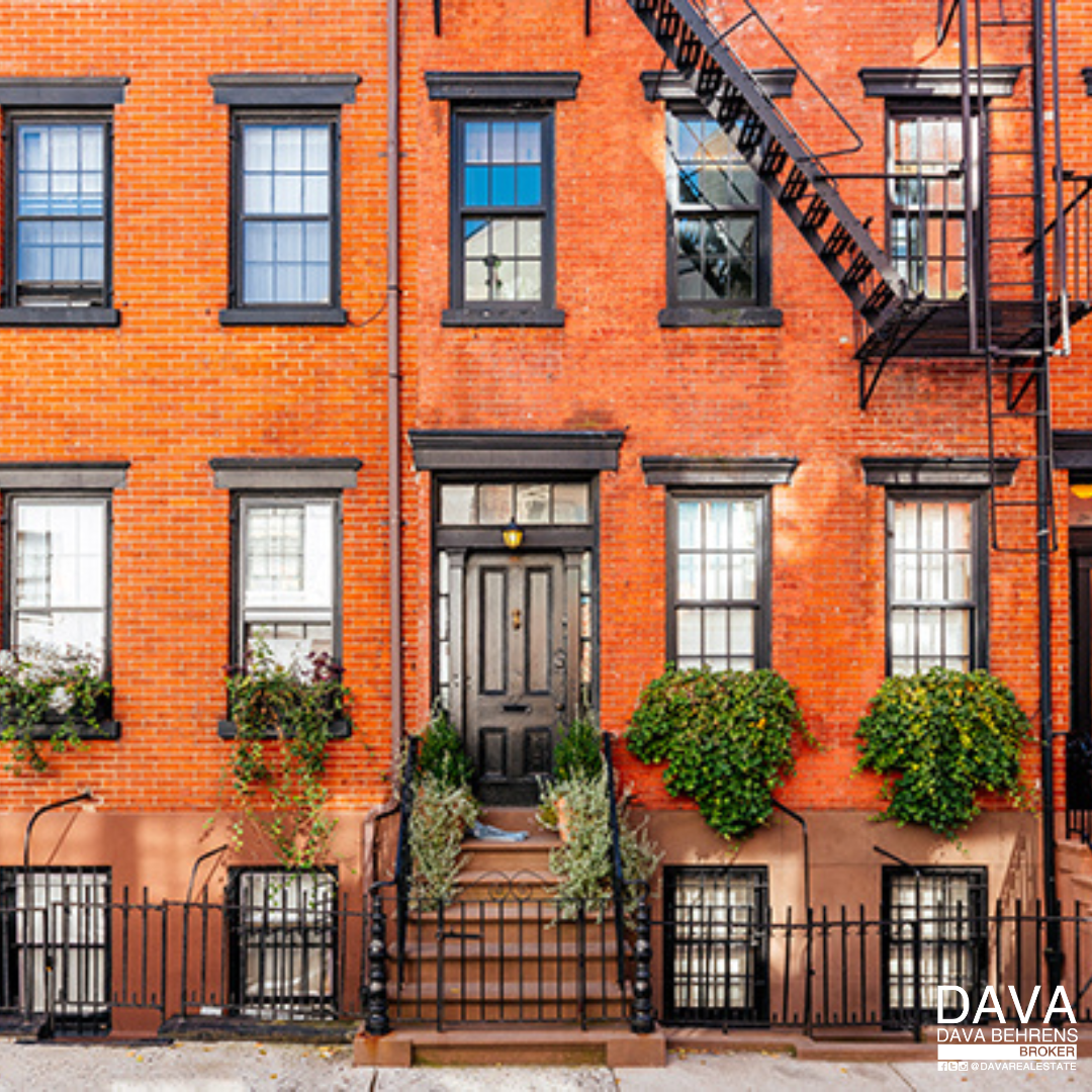 Brick townhouse with black windows and door.