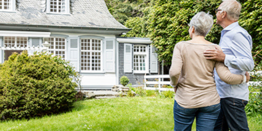 Senior couple admiring new house.