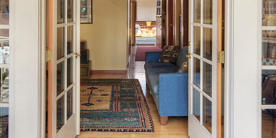 French doors open to hallway and living room.