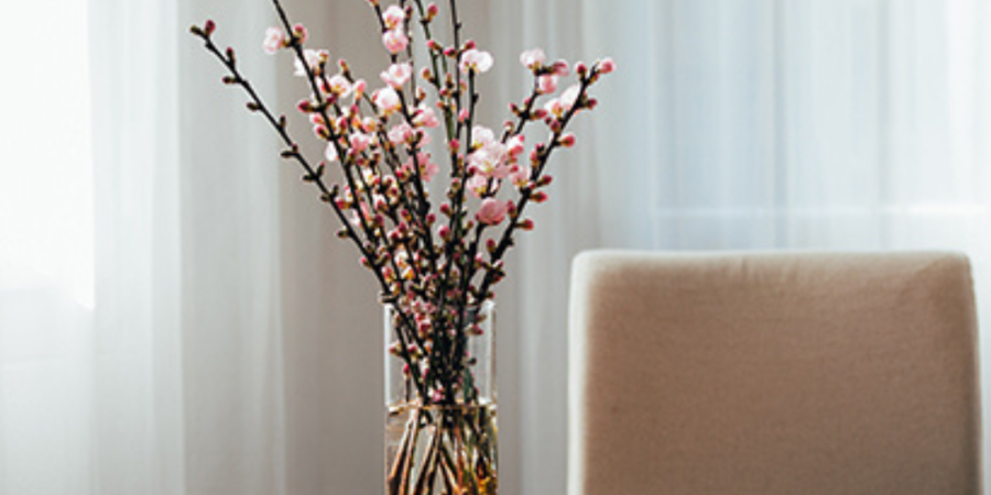 Pink flowers in glass vase on table.